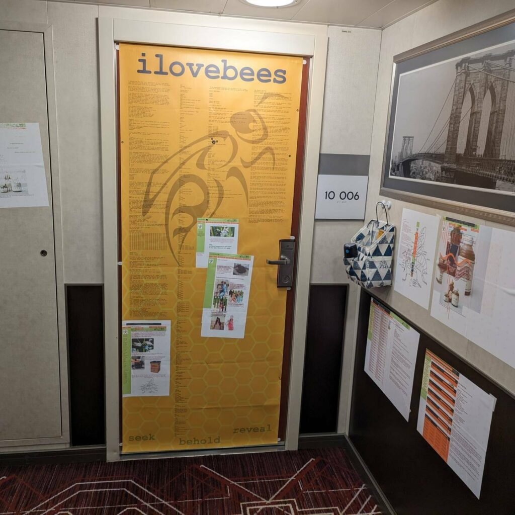 A decorated door with an ilovebees theme. The door and surrounding walls have images of hacked webpages attached to them. 